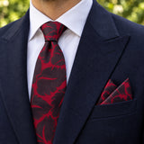 Crimson Leaf Silhouette silk tie and matching pocket square — Navy peak lapel · pointed fold