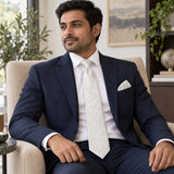 Ivory Scroll Damask silk tie and matching pocket square — Navy suit · seated lifestyle