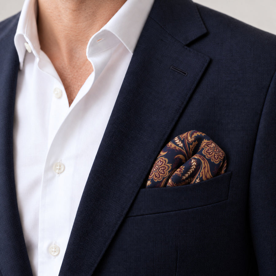 Midnight Copper Paisley Silk Pocket Square — Navy jacket · rounded puff