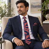 Navy Coral Laurel Leaf silk tie and matching pocket square — Navy suit · seated lifestyle