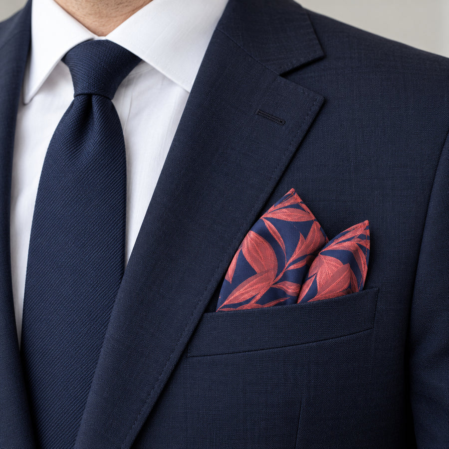 Navy Coral Laurel Leaf Silk Pocket Square — navy jacket · pointed fold.