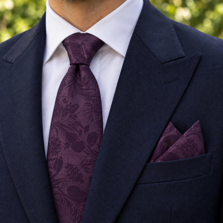 Plum Tropical Bloom silk tie and matching pocket square — Navy peak lapel · pointed fold