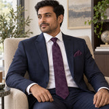 Plum Tropical Bloom silk tie and matching pocket square — Navy suit · seated lifestyle