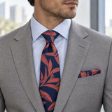 Navy Coral Laurel Leaf silk tie and matching pocket square — Stone grey · pale blue shirt