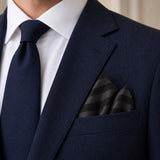 Noir Shadow Striped Silk Pocket Square — Navy jacket · pointed fold