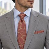 Terracotta Leaf Silhouette silk tie and matching pocket square — Stone grey · pale blue shirt